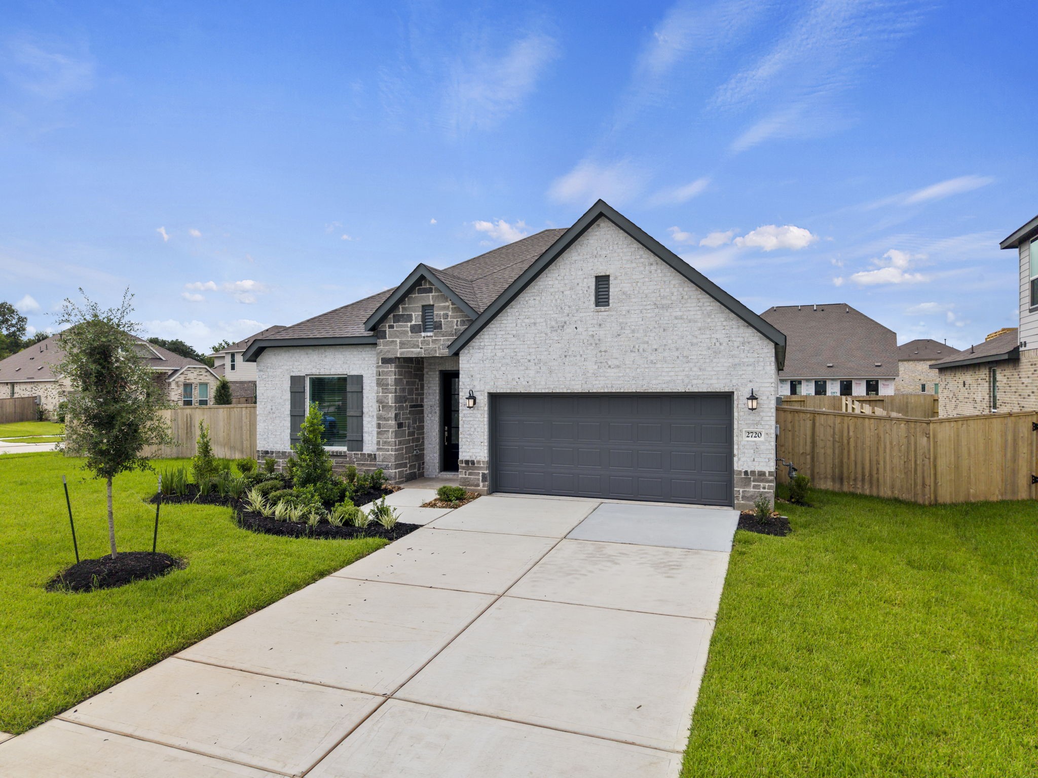 2720 Grove Crest Drive Rosenberg, TX 77469 - Photo 2 of 32 Stunning curb appeal with a sophisticated brick-and-stone exterior, landscaped front yard, and two-car garage.