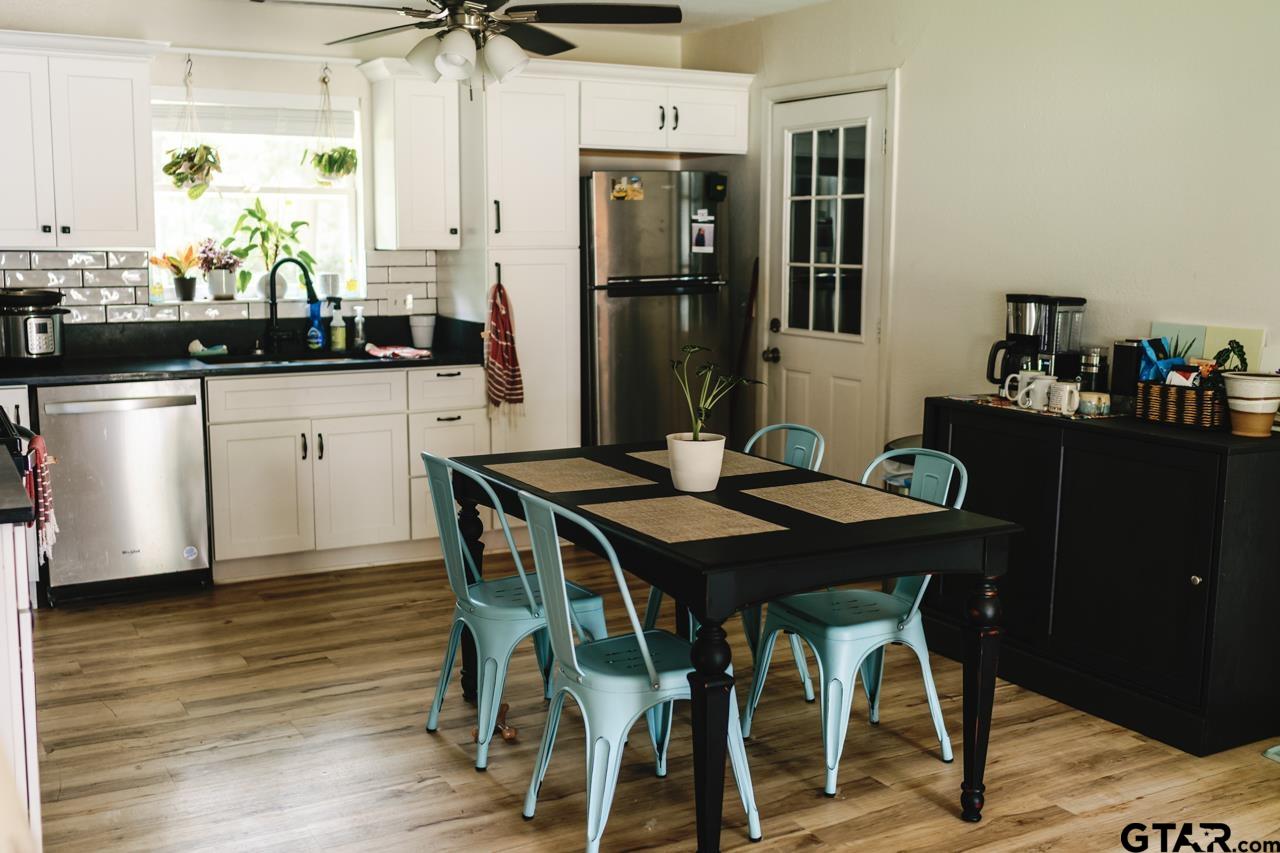2411 Rodge Drive Tyler, TX 75701 - Photo 6 of 42 a kitchen with stainless steel appliances kitchen island granite countertop a table chairs sink and cabinets