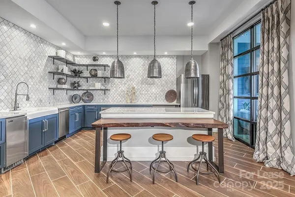 a kitchen with a sink a stove and chairs