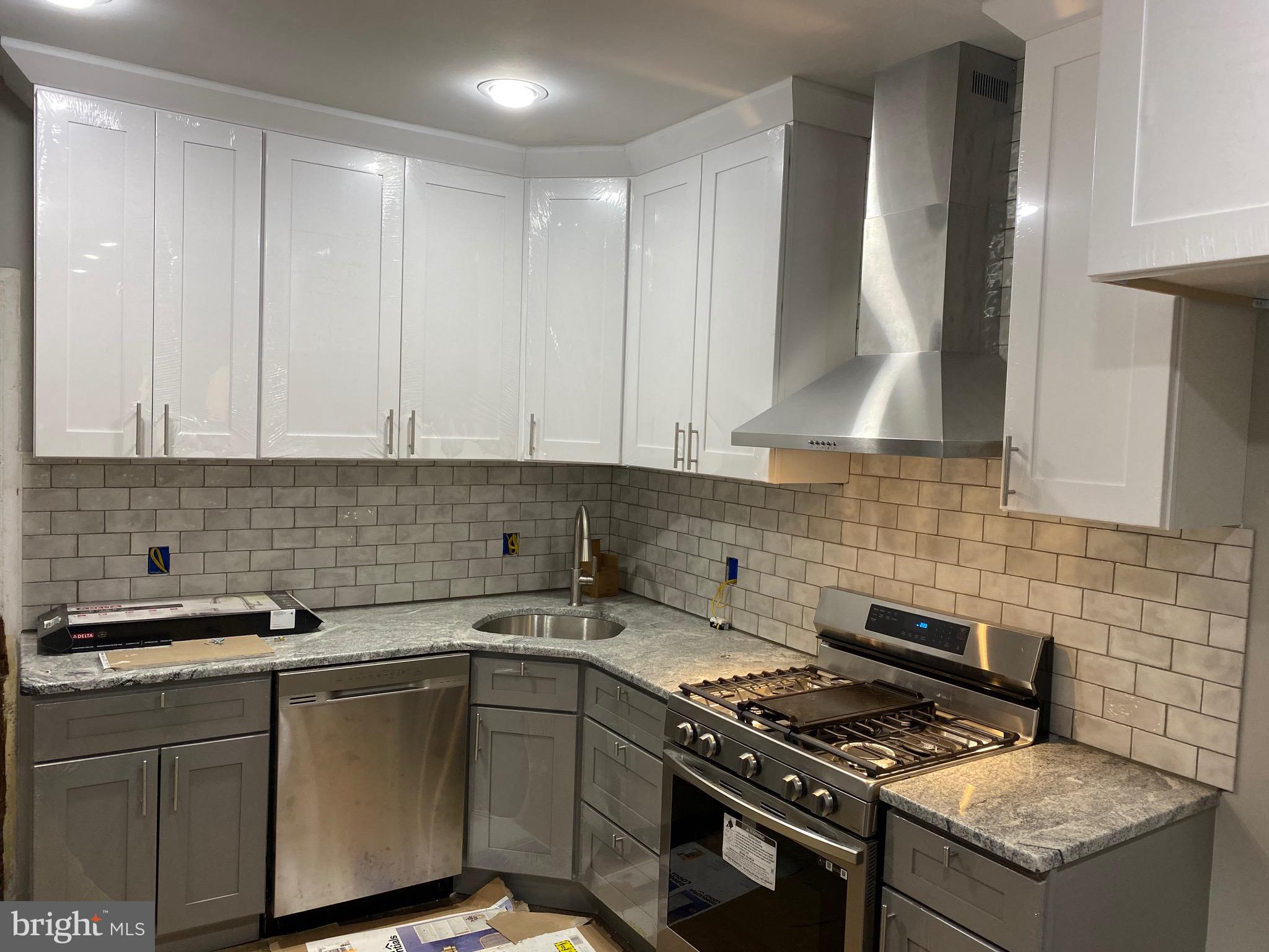 3167 East Thompson Street Philadelphia, PA 19134 - Photo 5 of 26 a kitchen with granite countertop a stove sink and cabinets