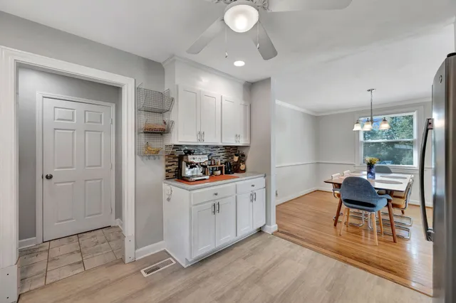 a kitchen with white cabinets and wooden floor