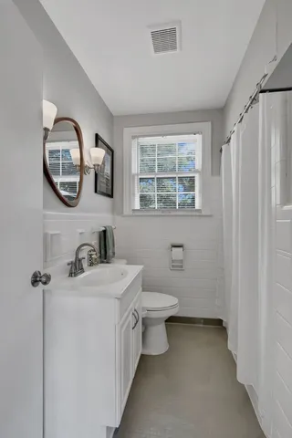 a bathroom with a toilet sink and mirror