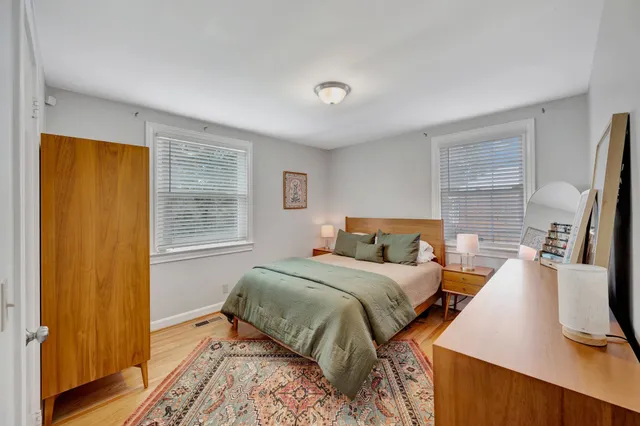 a bedroom with a bed and a flat tv screen on a dresser