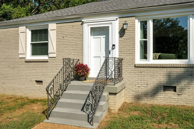 a view of a brick house with potted plants