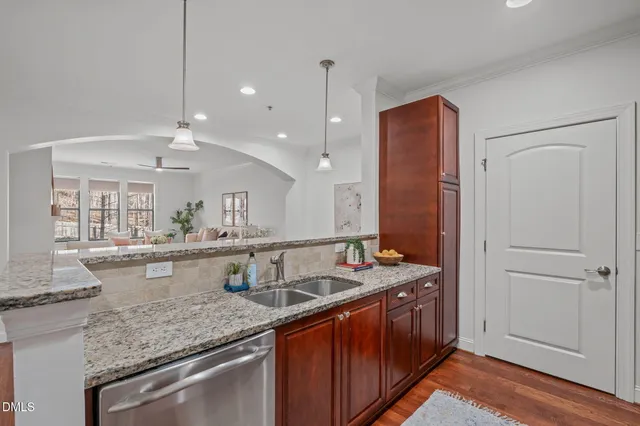 a kitchen with granite countertop cabinets a sink a window and stainless steel appliances