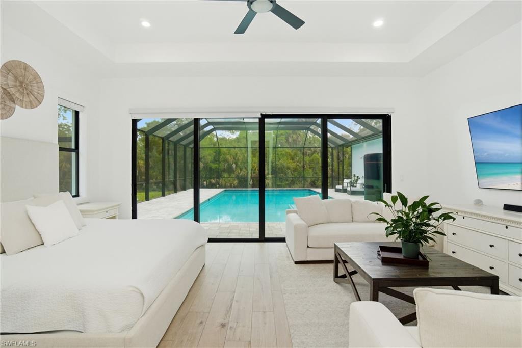 522 31st Street Southwest Naples, FL 34117 - Photo 20 of 38 Spacious interior room featuring light wood-finish flooring, a tray ceiling with recessed lighting, and a ceiling fan