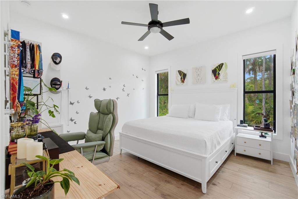522 31st Street Southwest Naples, FL 34117 - Photo 24 of 38 Hardwood-finish flooring featuring recessed lighting, a ceiling fan, and multiple large windows with black frames
