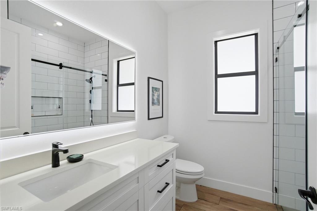 522 31st Street Southwest Naples, FL 34117 - Photo 27 of 38 Contemporary bathroom featuring a white vanity with shaker-style cabinetry, a rectangular undermount sink, and a quartz-finish countertop