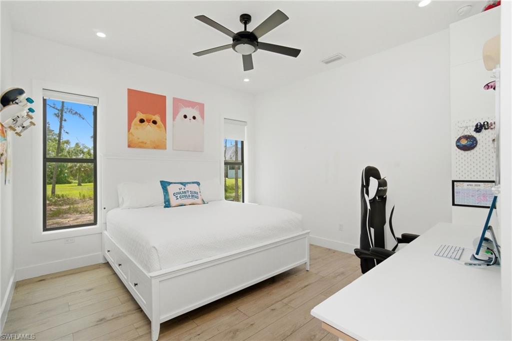 522 31st Street Southwest Naples, FL 34117 - Photo 28 of 38 Bright bedroom featuring wood-finish flooring, a contemporary ceiling fan, and recessed lighting