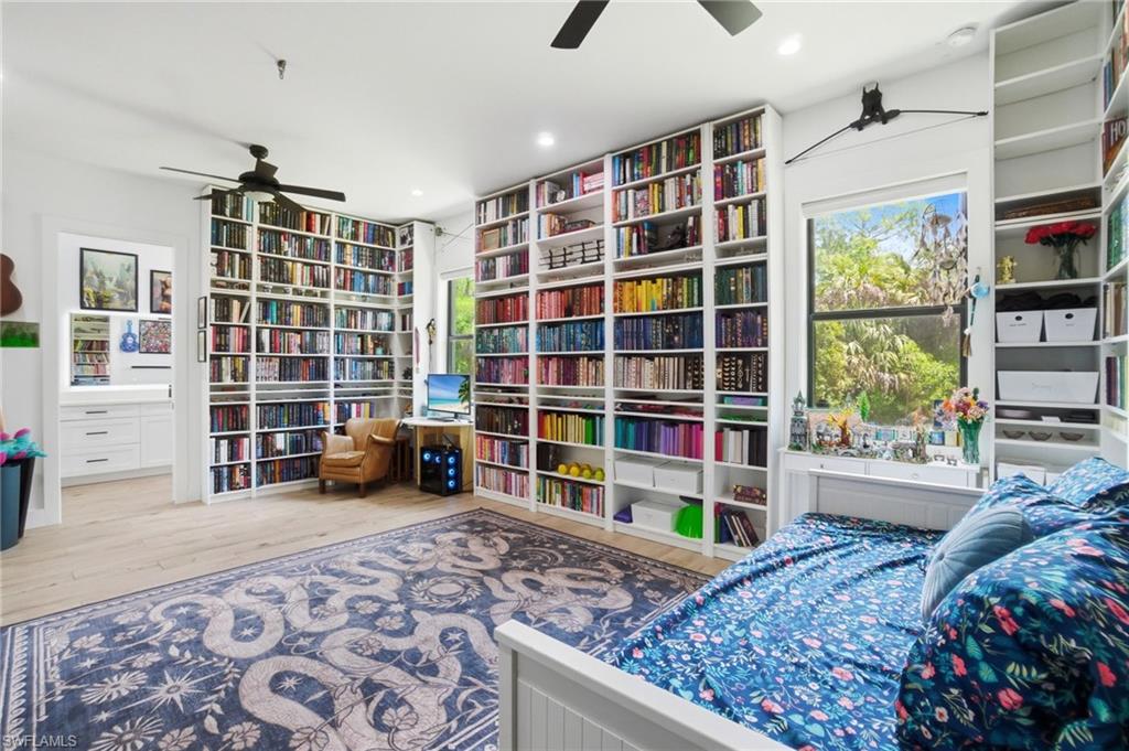 522 31st Street Southwest Naples, FL 34117 - Photo 31 of 38 Room featuring extensive built-in shelving, wood-finish flooring, and a ceiling fan