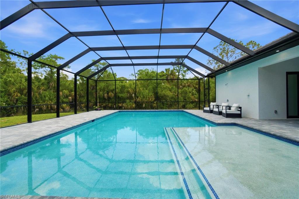 522 31st Street Southwest Naples, FL 34117 - Photo 37 of 38 Screened lanai with a rectangular pool and integrated spa