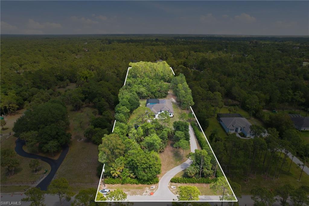 522 31st Street Southwest Naples, FL 34117 - Photo 6 of 38 Aerial view showcasing a substantial parcel of land, featuring mature trees and a main residence with a light-colored roof