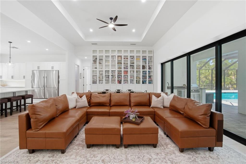 522 31st Street Southwest Naples, FL 34117 - Photo 9 of 38 Open-concept living space featuring a tray ceiling with a ceiling fan