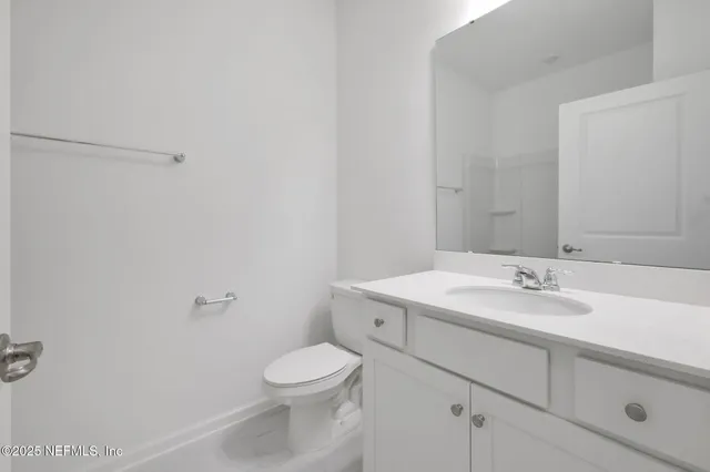 a bathroom with a toilet sink vanity and mirror