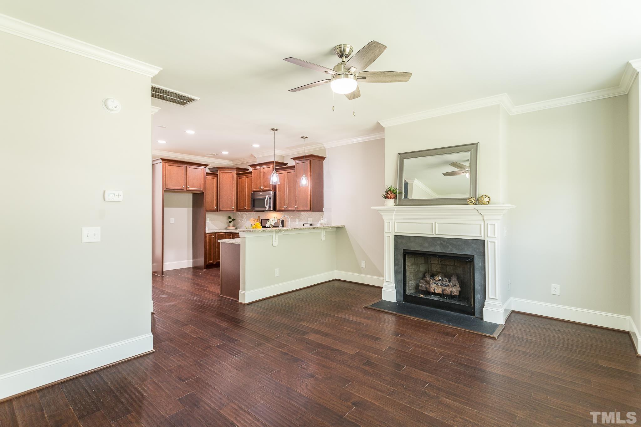 2824 Plumfield Place Raleigh, NC 27607 - Photo 9 of 21 a view of a kitchen with a ceiling fan a fireplace and wooden floor