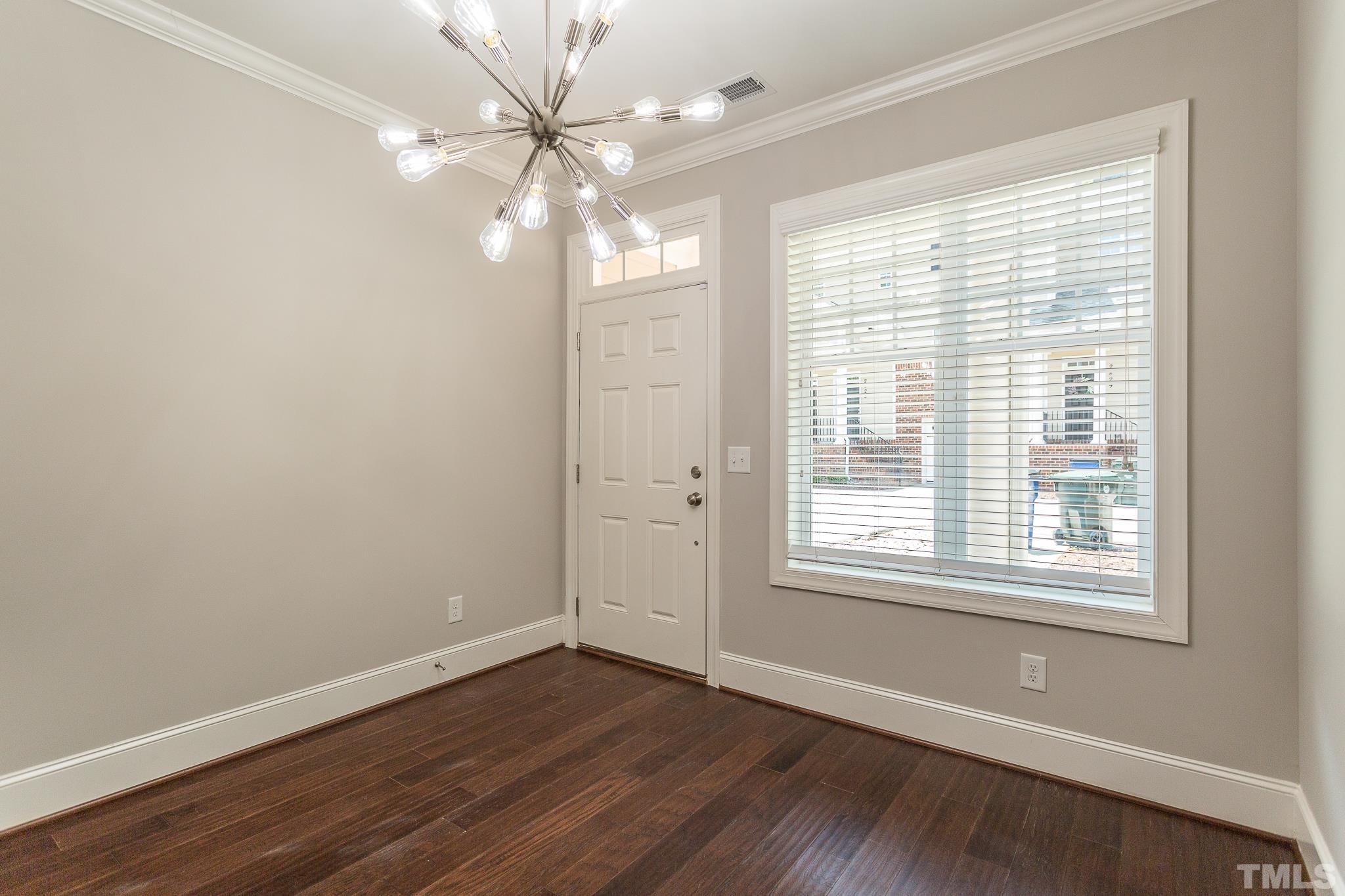 2824 Plumfield Place Raleigh, NC 27607 - Photo 10 of 21 a view of an empty room with wooden floor and a window