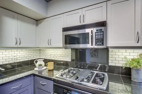 a kitchen with granite countertop stainless steel appliances a stove sink and cabinets