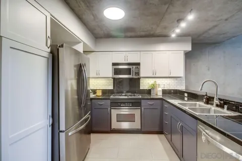 a kitchen with stainless steel appliances granite countertop a stove sink and refrigerator
