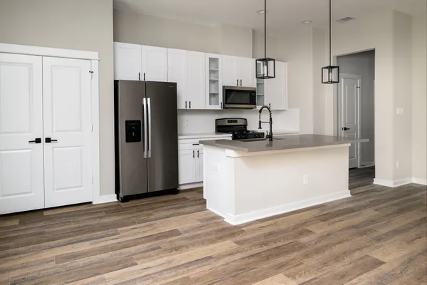 a kitchen with stainless steel appliances a refrigerator stove microwave and cabinets