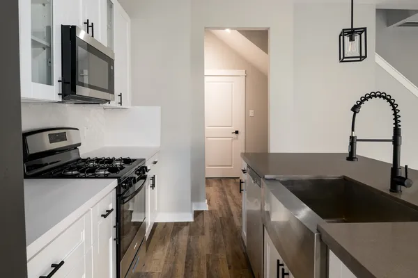 a kitchen with granite countertop a sink stove and refrigerator