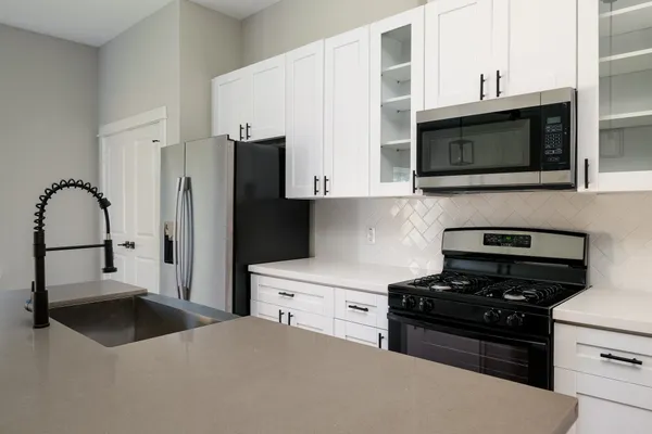 a kitchen with stainless steel appliances a stove a sink and a microwave