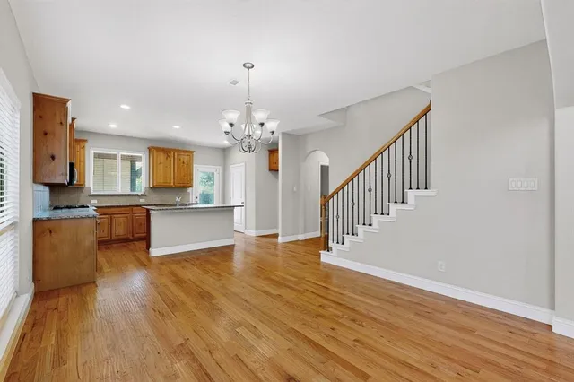 a view of a kitchen with granite countertop stainless steel appliances and wooden floor