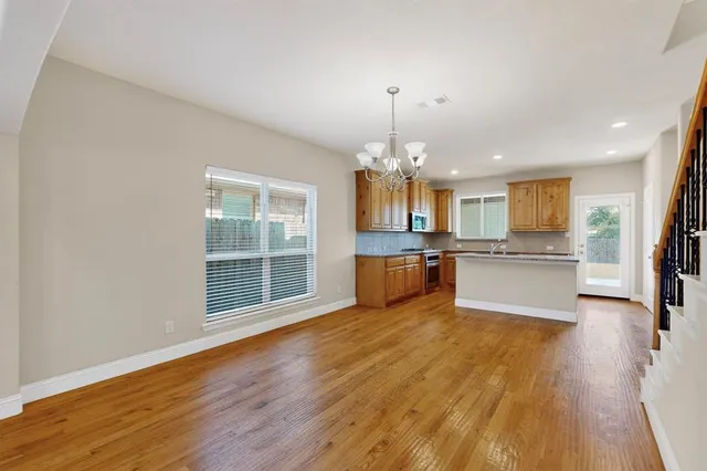 a kitchen with stainless steel appliances granite countertop a stove a sink and a microwave