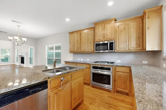 a kitchen that has a sink a stove and a wooden floor