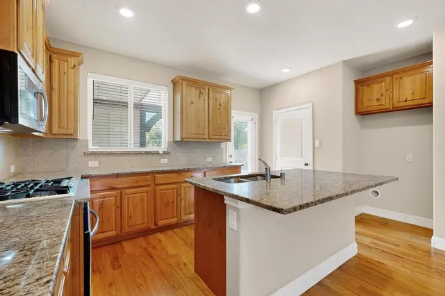 a kitchen with stainless steel appliances granite countertop a sink stove and cabinets
