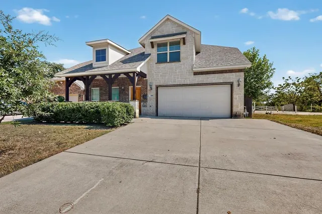 a front view of a house with a garden and garage