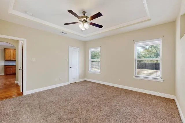 an empty room with windows and fan