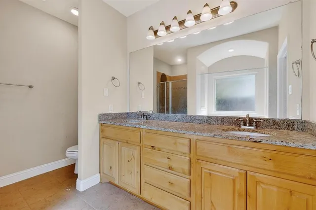 a bathroom with a granite countertop double vanity sink mirror and