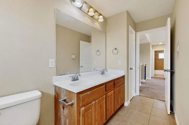 a spacious bathroom with a sink a toilet and a mirror