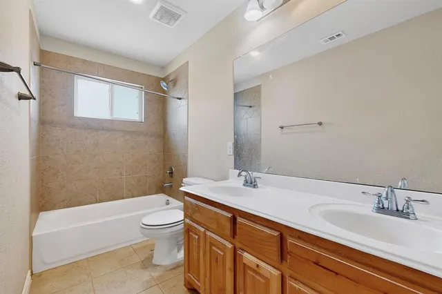 a bathroom with a granite countertop sink a toilet and shower