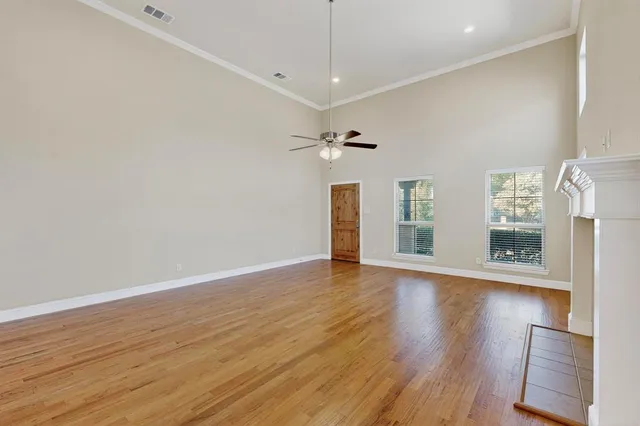 a view of a livingroom with wooden floor a fireplace and a window