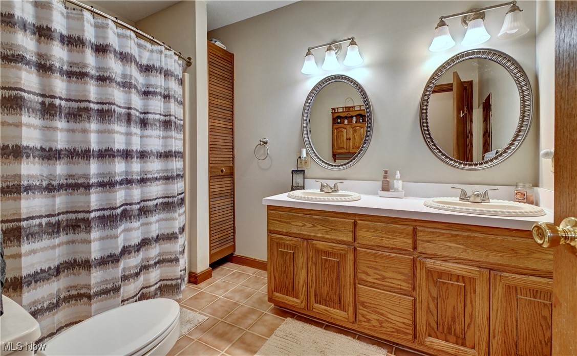 5747 Middle Run Road Dover, OH 44622 - Photo 18 of 30 Full bathroom featuring light tile patterned floors, double vanity, and curtained shower