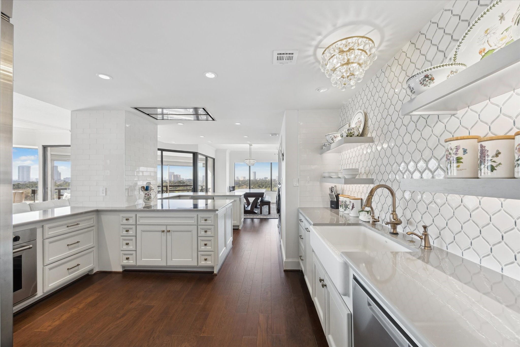 101 Westcott Street, Unit 1202 Houston, TX 77007 - Photo 16 of 38 a large kitchen with granite countertop a sink dishwasher a stove a dining table and chairs with wooden floor