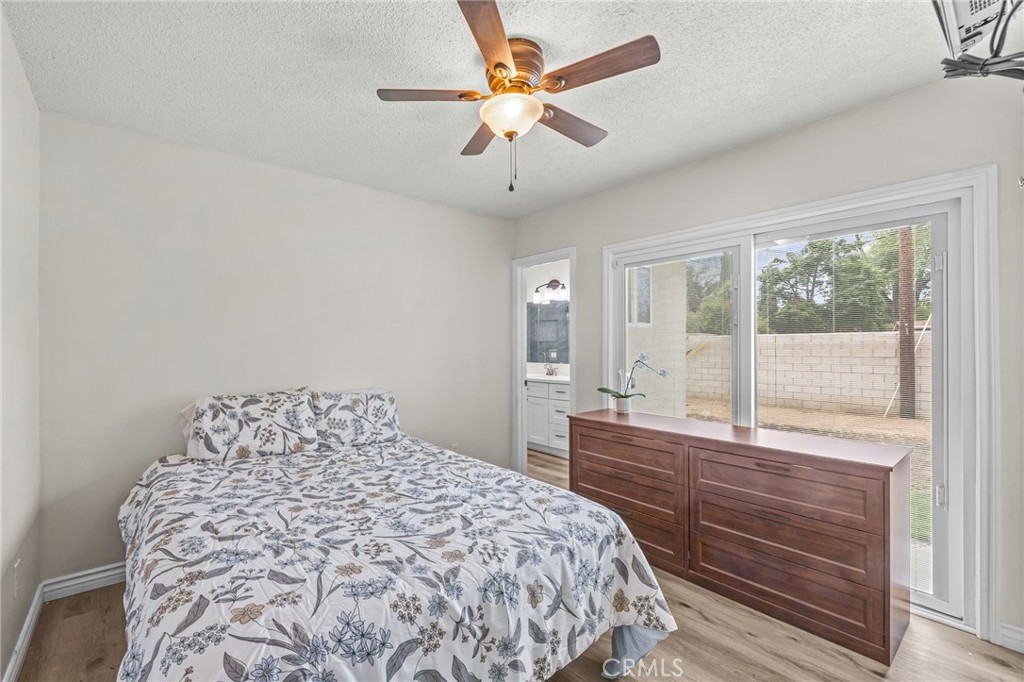 10028 Primrose Drive Riverside, CA 92503 - Photo 9 of 19 a bedroom with a large bed and a chandelier fan