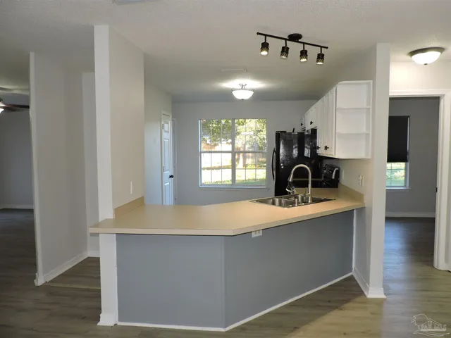 a kitchen with sink cabinets and wooden floor