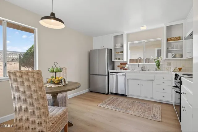 a kitchen with stainless steel appliances granite countertop a stove and white cabinets