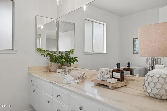 a bathroom with a toilet a sink a vanity and mirror