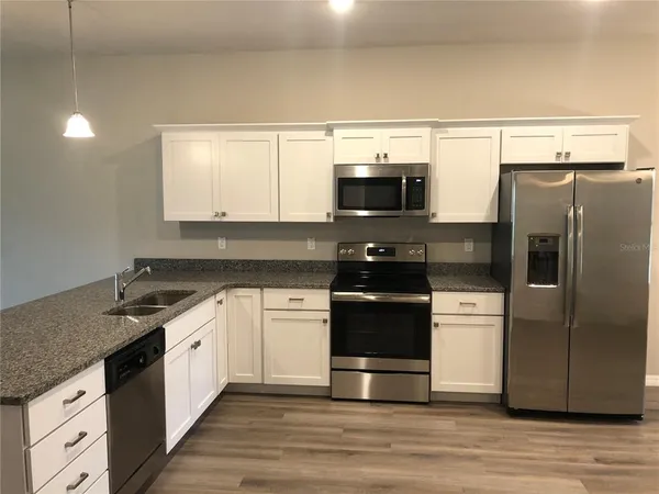 a kitchen with stainless steel appliances a stove a sink and a refrigerator