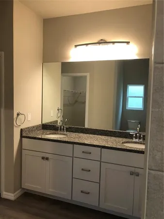 a bathroom with a granite countertop sink and a mirror