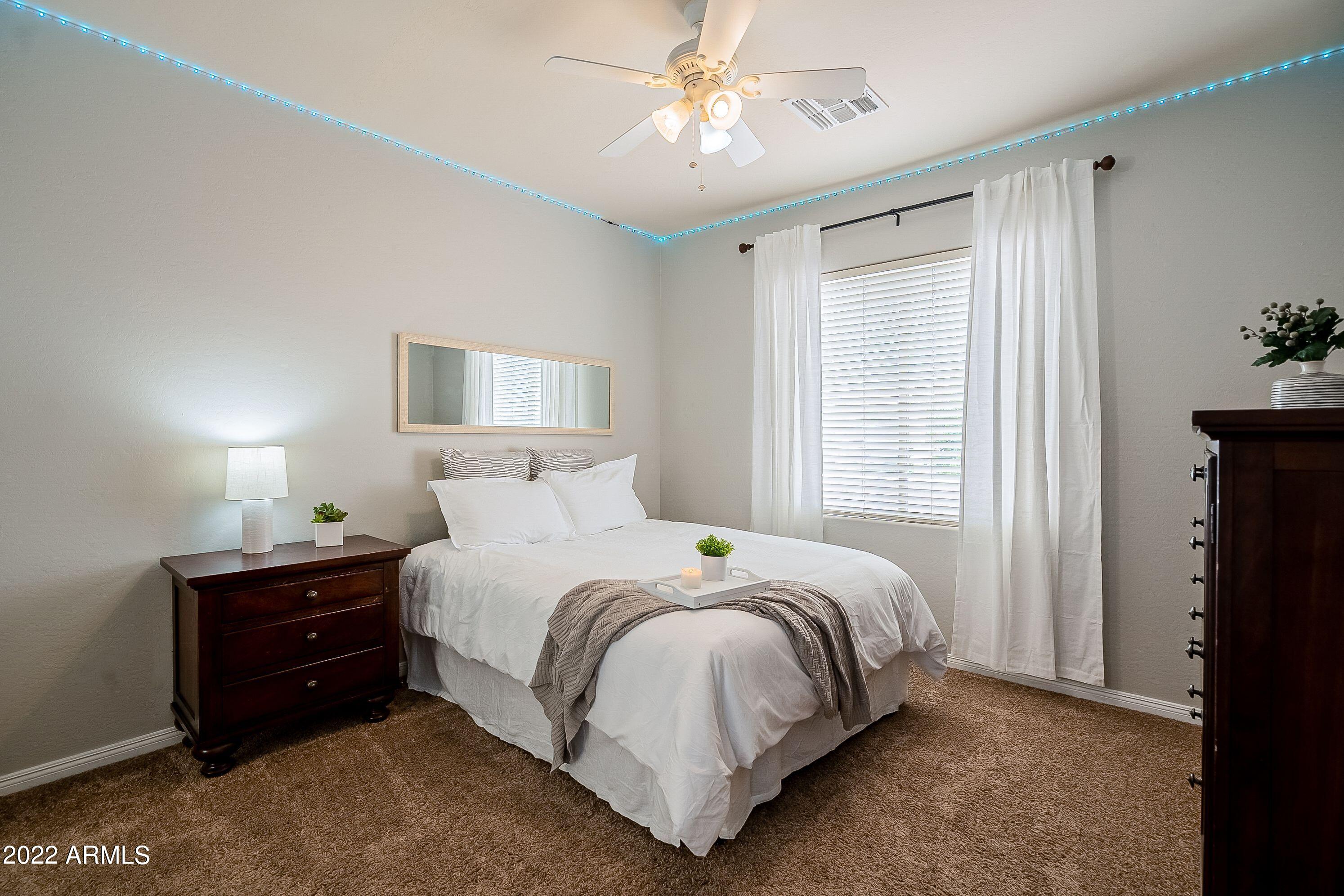 4770 East Buckboard Road Gilbert, AZ 85297 - Photo 61 of 97 a bedroom with a bed lamp and a chandelier