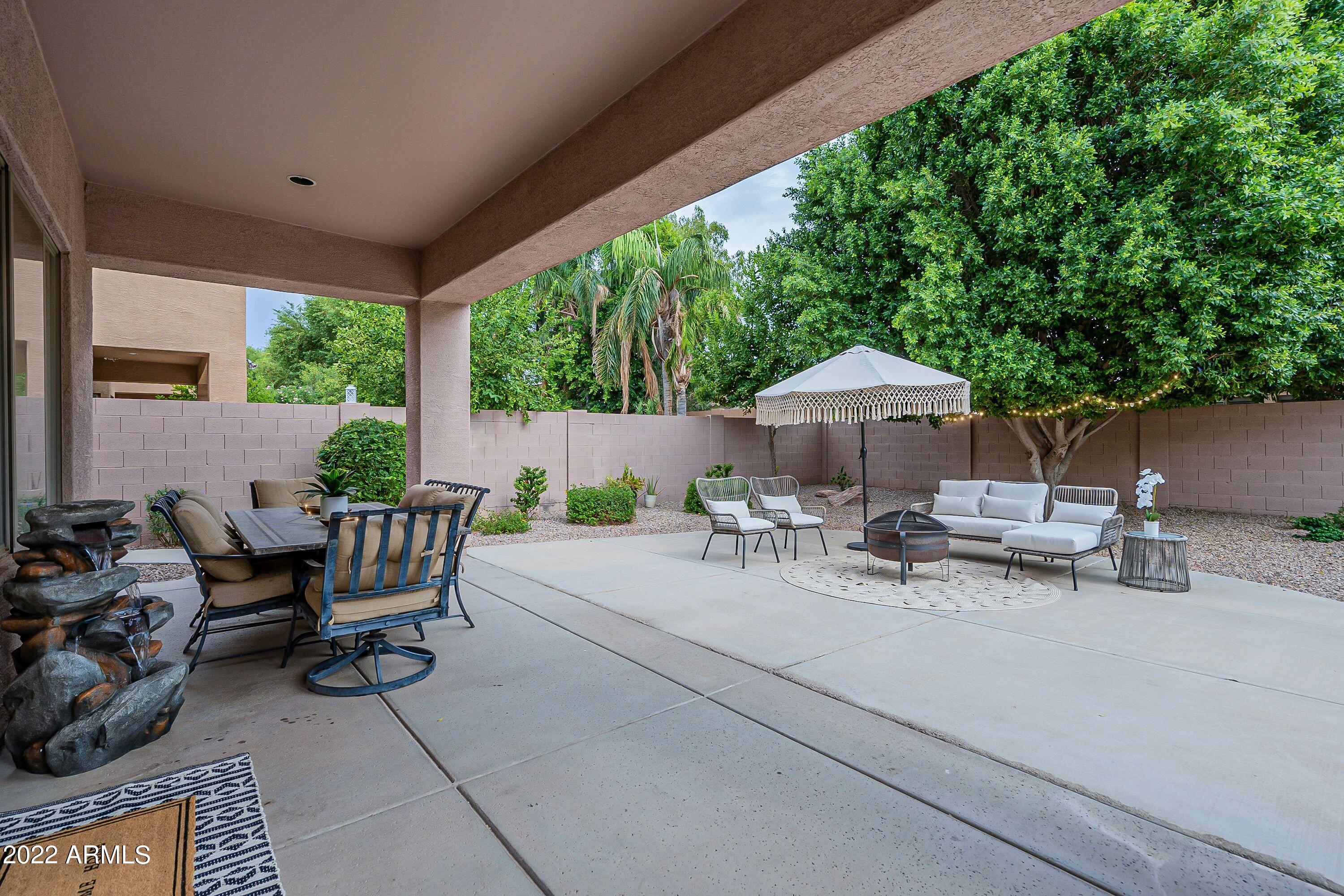 4770 East Buckboard Road Gilbert, AZ 85297 - Photo 73 of 97 a view of a patio with table and chairs potted plants with wooden fence