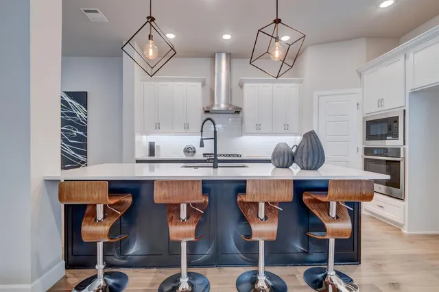 a kitchen with cabinets and chairs