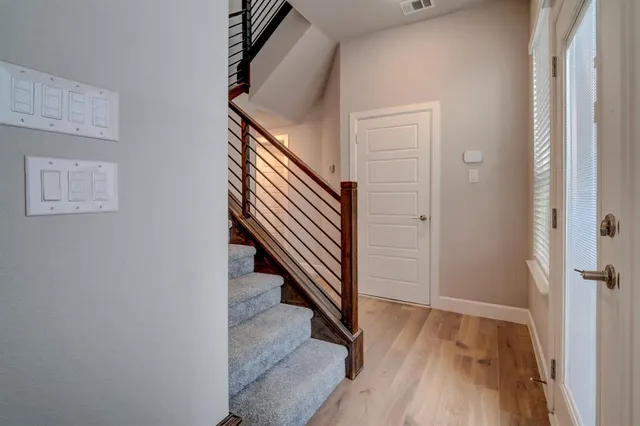a view of a hallway with wooden floor and entryway
