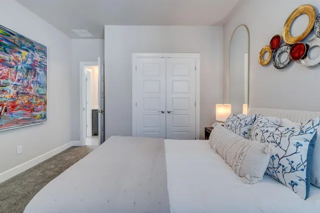 a bedroom with a bed and a painting on the wall