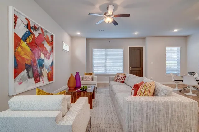 a living room with furniture ceiling fan and a rug