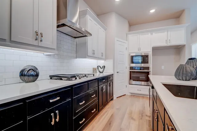 a kitchen with stainless steel appliances a stove a sink a refrigerator and cabinets